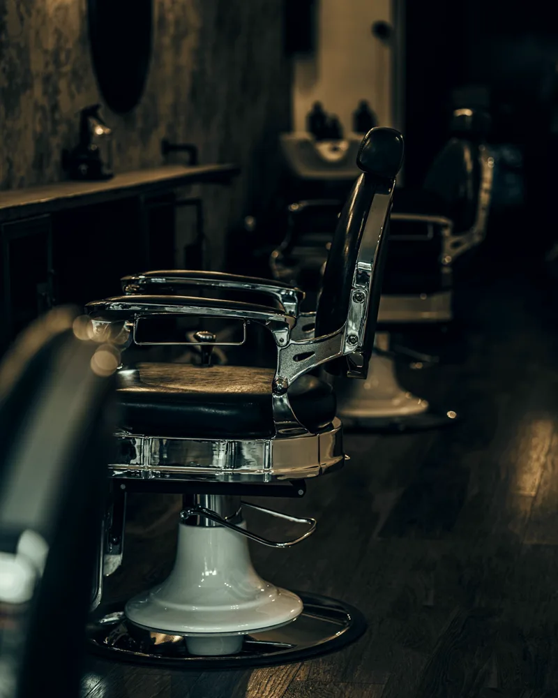 Klassischer Barberstuhl aus schwarzem Leder mit Chromgestell – Symbolfoto